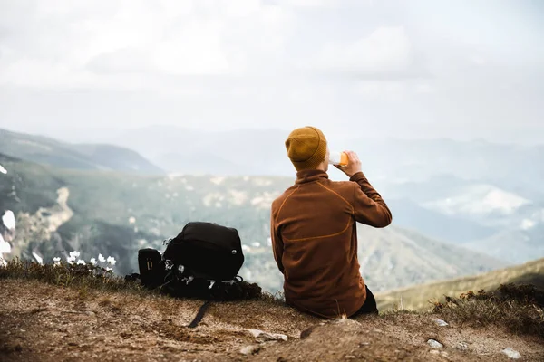 Turysta Pije Wodę Skraju Szczytu Góry Mgliste Góry Tle Fotografia — Zdjęcie stockowe