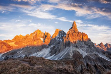 Pale di San Martino mountain group in sunset time. Hight mountains with glacier glowing by sunset light. San Martino di Castrozza, Dolomites, Trentino, Italy