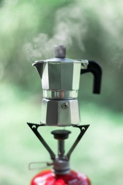Küçük kahve makinesinin üstünde kamp ateşinde kahve yapmak.