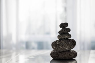 Piramitte istiflenmiş masadaki spa tedavileri için taşlar. Meditasyon ve denge kavramı