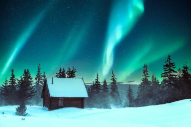 Karlı çam ağaçları ve bir dağ çayırındaki ahşap kulübe kışın çekilen bir manzarada. Aurora borealis. Kuzey ışıkları kış ormanında. Noel tatili ve kış tatili konsepti