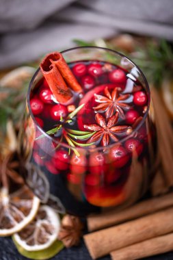 Bir bardak portakal dilimli sıcak şarap, tarçın çubuğu, yıldız anason, biberiye ve kızılcık. Yemek fotoğrafçılığı
