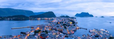 Akşam vakti Norveç liman kenti Alesund 'un panoraması. Fiyortlu, adalı, dağlı, tekneli ve tipik Norveç evleriyle Norveç şehri