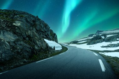 Aurora borealis Kuzey ışıkları Norveç 'in ünlü karlı dağ yolunun üzerinde kış gökyüzü