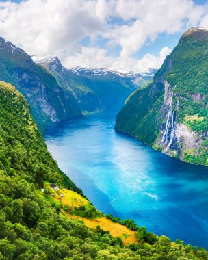 Stunning view of the clear azure waters of Sunnylvsfjorden fjord and the renowned Seven Sisters waterfalls near the village of Geiranger in western Norway