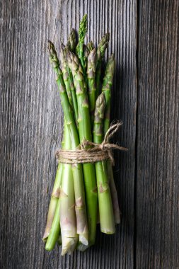 Eski kırsal masada taze yeşil kuşkonmaz filizleri var. Üst Manzara. Yemek fotoğrafçılığı