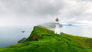 Mykines Holmur Deniz Feneri. Danimarka 'nın Faroe Adaları' ndaki Mykines Adası 'nın yeşil tepelerinde. Peyzaj fotoğrafçılığı