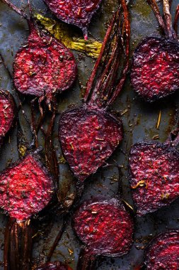 Fırında pişirdikten sonra pişmiş pancar dilimleri. Üst Manzara. Kavrulmuş pancar ve baharat. Zeytinyağı, tuz ve biberli fırında pancar.