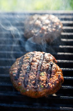 Izgara burger köftesi ve sıcak ızgara, yakın çekim. Kızarmış ızgarada alevler içinde hamburger pişirmek.
