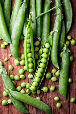 Yeşil bezelye kırsal ahşap masada. Yaklaş. Yeşil bezelye fasulyesi sebzesi. Yemek fotoğrafçılığı