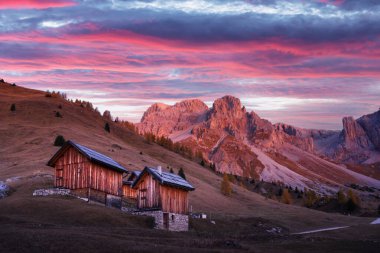 Sonbaharda İtalyan Dolomitleri 'nin Fuchiade vadisinde tahta kulübeler, turuncu tarlalar ve dağlar. Dolomit Alpleri, İtalya. Peyzaj fotoğrafçılığı