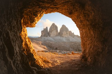 Tre Cime Di Lavaredo 'daki mağaranın manzarası inanılmaz turuncu gün batımı ışığında. Lavaredo 'nun üç tepesi, Dolomite Alpleri, İtalya, Avrupa. Peyzaj fotoğrafçılığı