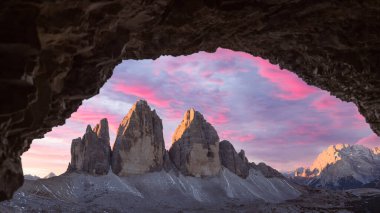 Tre Cime Di Lavaredo 'daki mağaranın panoramik manzarası inanılmaz mor gündoğumu ışığıyla doruğa ulaşır. Lavaredo 'nun üç tepesi, Dolomite Alpleri, İtalya, Avrupa. Peyzaj fotoğrafçılığı