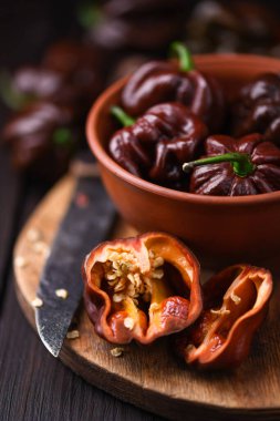 Olgunlaşmış çikolatalı habanero biberleri ahşap kesim tahtasının üzerinde chincum chinense. Çok sıcak Meksika biberleri kırsal ahşap masada. Yaklaş.