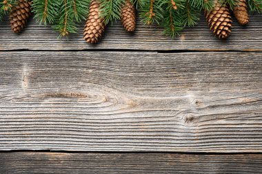 Yeşil köknar ağacı dalları ve çam kozalaklarından oluşan yeni yıl arkaplanı. Rustik Ahşap Süs Arkaplanı