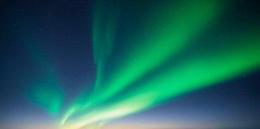 Yeşil kutup ışıkları ve yıldızlı mavi gökyüzü. Aurora borealis Kuzey ışıkları kış gökyüzünde