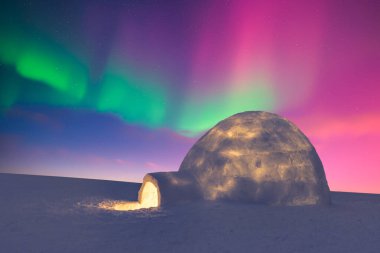 Aurora borealis. Kış tarlasında kuzey ışıkları. Parlayan kutup ışıkları ve karlı igloo ile kış sahnesi. Noel kartpostalı