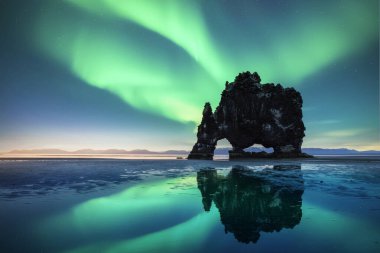 Aurora borealis Northern lights over Basalt stack Hvitserkur on the Vatnsnes peninsula, Iceland. Gorgeous Icelandic landscape with Polar lights clipart