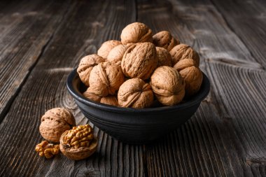 Tahta masadaki siyah kasede ceviz fıstığı. Yaklaş. Yemek fotoğrafçılığı