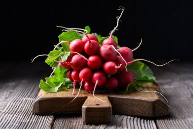 Tahta kesme tahtası ve taze organik kırmızı turp. Yemek fotoğrafçılığı