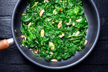 Demir tava ve haşlanmış ıspanak. Sağlıklı vejetaryen yemeği. Üst görünüm