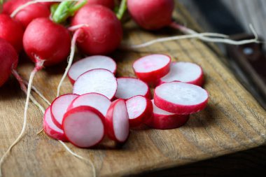 Tahta kesme tahtasındaki taze organik turp dilimleri. Yemek fotoğrafçılığı