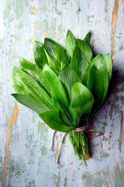 Kırsal ahşap masadaki yabani sarımsak yaprakları. Yemek fotoğrafçılığı