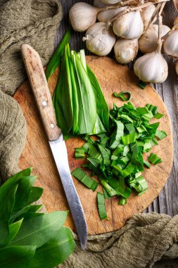 Tahtada yabani sarımsak yaprakları, bıçakla yeni kesilmiş. Yemek tasarımı yakın çekim