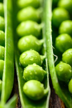Yeşil bezelyeli bezelye ve su damlalarının makro fotoğrafları. Gıda tasarımı için taze sebze yakın çekim