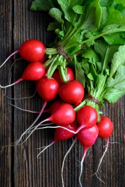 Tahta masadaki yeşilliklerle birlikte taze organik turp. Yemek fotoğrafçılığı