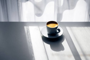 Pencerenin yanında sabah espresso kahvesi ve doğal ışık. Minimalist yemek ve içki shot 'ı