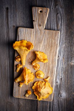 Mantarlı mantarların ahşap masadaki kırsal kesim tahtasının en üst görüntüsü. Yemek fotoğrafçılığı