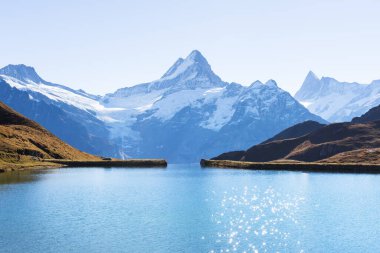 İsviçre Alpleri 'ndeki Bachalpsee Gölü' nde güneşli bir gün. Arka planda Wetterhorn, Mittelhorn ve Rosenhorn 'un karlı zirveleri var. Grindelwald Vadisi, İsviçre. Peyzaj fotoğrafçılığı