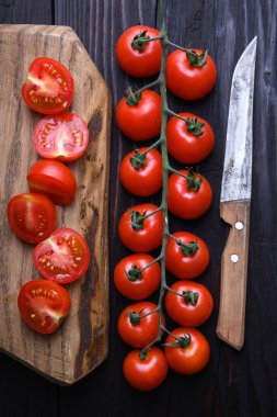 Ahşap masada bıçaklı kırmızı kiraz domatesleri. Üst Manzara. Yemek fotoğrafçılığı
