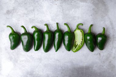 Yeşil Meksika biberlerinin üst görüntüsü metal levhada üst üste dizilmiş. Yemek fotoğrafçılığı