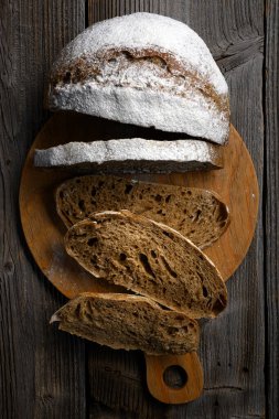 İştah açıcı çavdar ekmeği ekmek dilimlerinin rustik ahşap tahtada üst görüntüsü. Çiftlik usulü zanaatkar somunu kapat.
