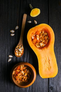 Tohumlu çiğ tereyağlı kabak ve ahşap masa üzerinde ahşap kaşık. Genel sonbahar sahnesi yemek içeriği ya da mevsimlik yemek fotoğrafçılığı için ideal