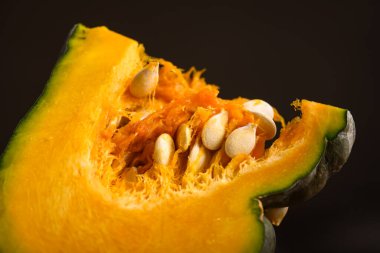 Çekirdekli yeşil balkabağı dilimini yakın çekim ile kes. Mevsimlik yemek fotoğrafçılığı