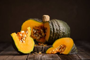 Canlı turuncu merkezli taze yeşil balkabağı bıçağın yanındaki kesme tahtasına dayanır. Şükran Günü ya da Cadılar Bayramı yemekleri sıcacık sonbahar ortamında