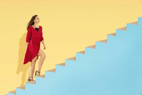 年轻女人走在抽象的楼梯上 — 图库照片