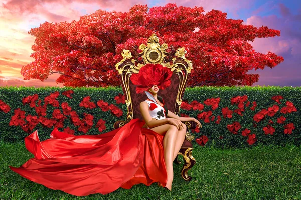 カードのシンボルで飾られた長いドレスを着た女性のシュールな描写は 花畑のあるシュールな風景の中に玉座に座っています 彼女の目は大きな赤い花で覆われており 陰謀と謎を加えています — ストック写真