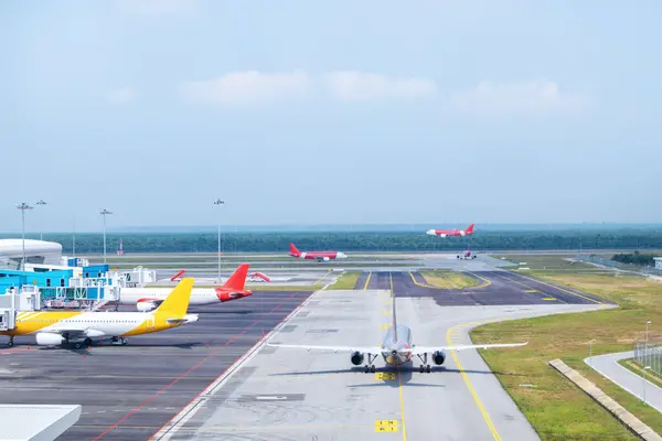 空港の建物 構造物および設備に囲まれたターミナル近くに駐車するさまざまな商用航空機を備えた忙しい空港ターマック滑走路 — ストック写真