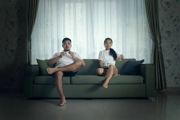 Ein Junges Paar Sitzt Lässig Gekleidet Auf Einer Grünen Couch — Stockfoto