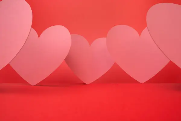 Formas Coração Rosa Tamanhos Variados Alinham Através Fundo Vermelho Brilhante Fotos De Bancos De Imagens
