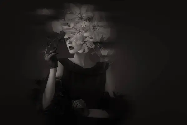 ダークメイク ラッシュカーリーヘア 濃い影の背景にスリルガイドの神秘的な女性のドラマチックな黒と白の肖像 ロイヤリティフリーのストック写真