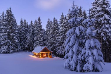 Kış manzarası. Karla kaplı bir çayırda ahşap kulübesi olan bir panorama. Yılbaşı fenerleri akşamları evi aydınlatır. Sarı çelenkler. Gizemli bir gece. Ormanlar.