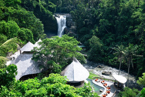 Top view of the waterfall. Tegenungan waterfall in jungle Ubud, Bali island Indonesia. Wallpaper background. Natural scenery. Photo of the summer cafe. Touristic resort.