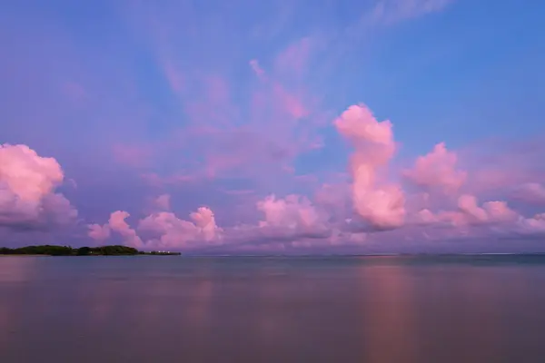Pink sky with clouds and ocean. Sunset scenery. Bali island, Indonesia. Wallpaper background. Natural scenery. Romantic relax place.