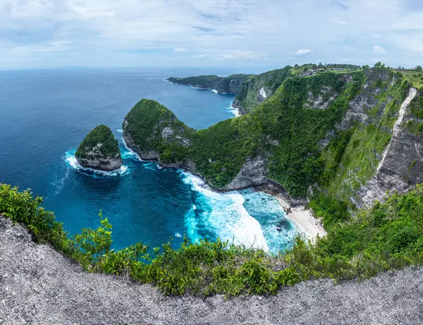 ターコイズの海 青い空 山々と晴れた日の風景 ケリングビーチはインドネシアのヌサペニダバリ島の信じられないほど小さな洞窟です マウンテンシーン 壁紙の背景 ストック写真