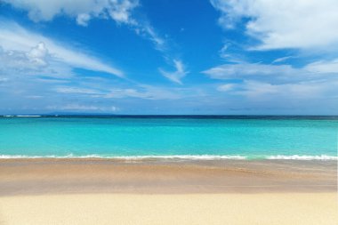 Bali adası, Endonezya, Nusa dua plajı. Tropik bir manzara. Beyaz kumsaldaki güzel yaz manzaralı okyanus. Mavi arkaplan.